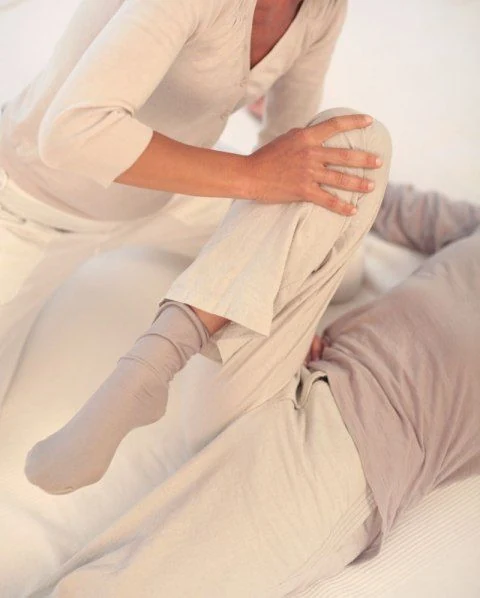 Manos sosteniendo la rodilla durante un estiramiento de pierna